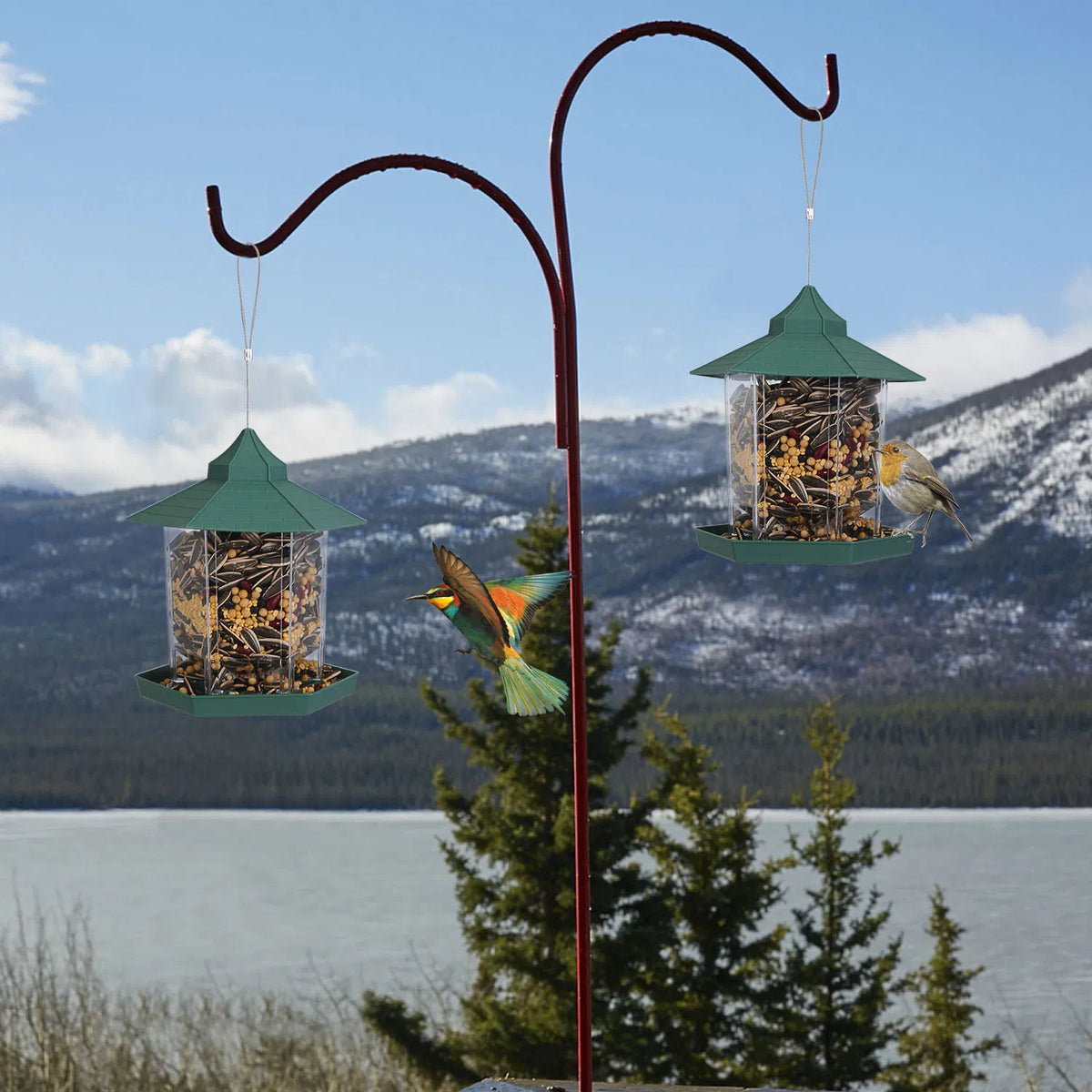 Two green gazebo bird feeders hanging from an outdoor shepherd’s hook